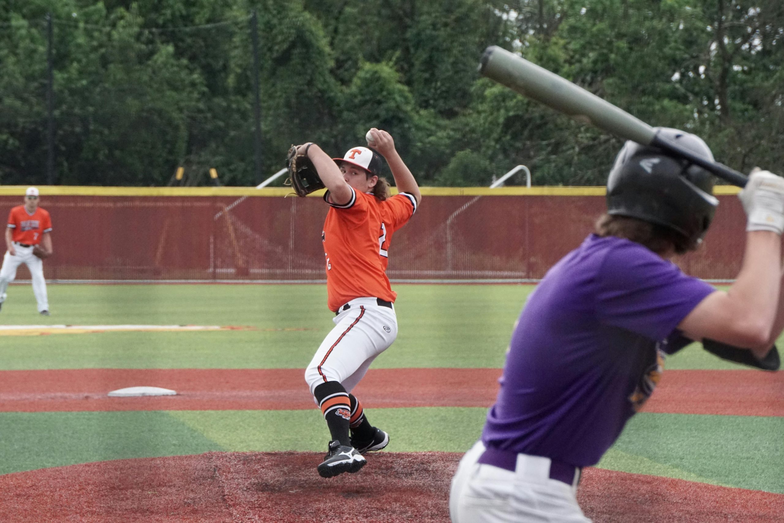 pitcher preparing to throw the ball as the batter waits at the home plate