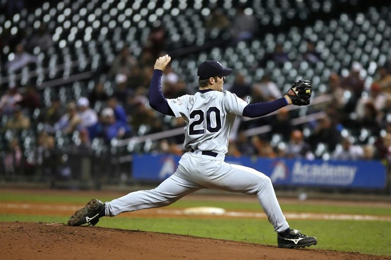 professional baseball player mid-pitch, gripping the ball tightly